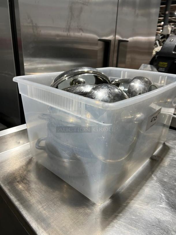 Commercial round braiser pans with dome-style lids in a clear plastic bin. Stainless steel, used condition.
