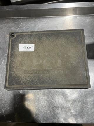 Commercial rectangular cutting board with visible wear, dark surface, engraved groove, and corner hole. Marked "48X4" tag.