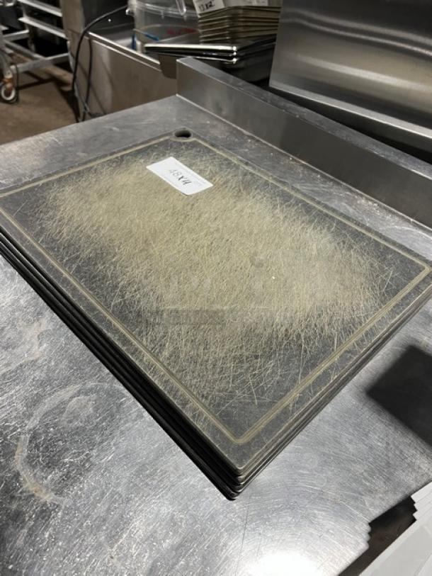 Commercial rectangular cutting board with wear marks, dark material, stackable design. Label: "12x18." Suitable for heavy use.