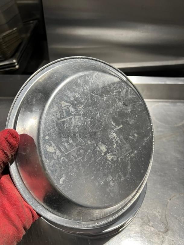 Commercial aluminum round pie pan, well-used condition, metallic finish, features scratch marks, no visible labels.