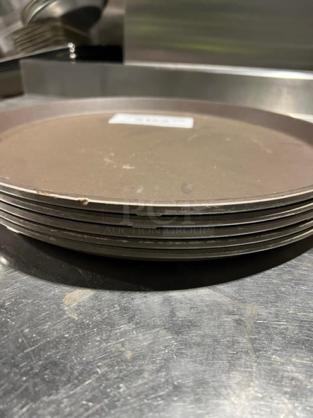 Cambro commercial brown round trays stacked, showing slight wear. Ideal for fast food or serving. No visible tags.