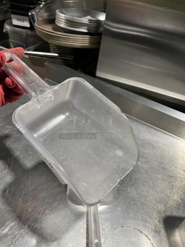 Clear handheld scoop, commercial grade, durable plastic. Excellent condition, ergonomic handle. Ideal for bulk item handling.