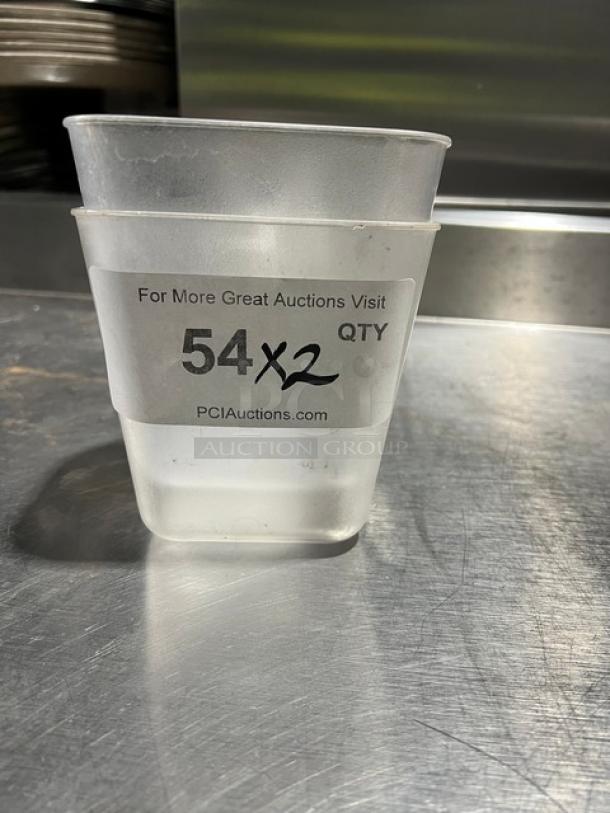 Commercial clear 20 oz. handheld measuring cup, lightly used, stack of two. Label indicates auction lot "54x2" from PCIAuctions.com.