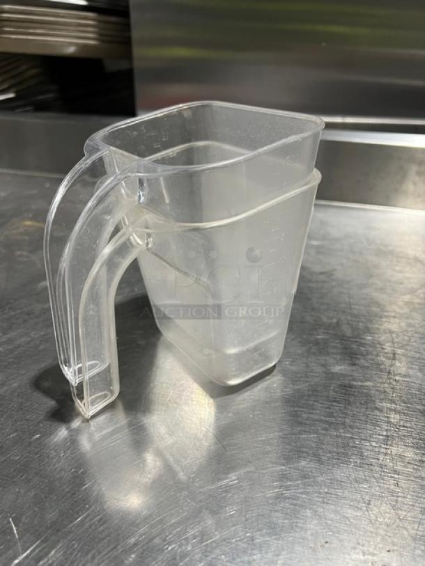 Clear 20 oz. handheld measuring cups, commercial grade, with ergonomic handles, stackable design, and capacity markings.