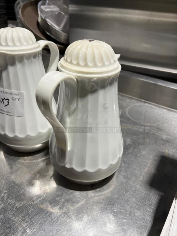 Commercial 42 oz. white swirl-design thermal coffee carafe, excellent condition, with a lid and handle. Auction label visible.