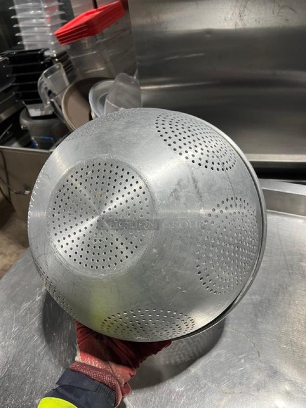 Commercial aluminum Chinese colander with round geometric pattern, used condition, smooth finish, no visible labels.