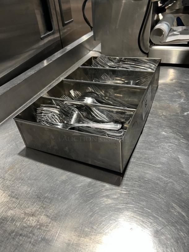 Lot of commercial forks in 4-compartment metal organizer, used condition, suitable for dinnerware storage.