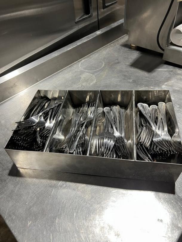 Steel 4-compartment utensil organizer containing assorted forks, suitable for commercial use.