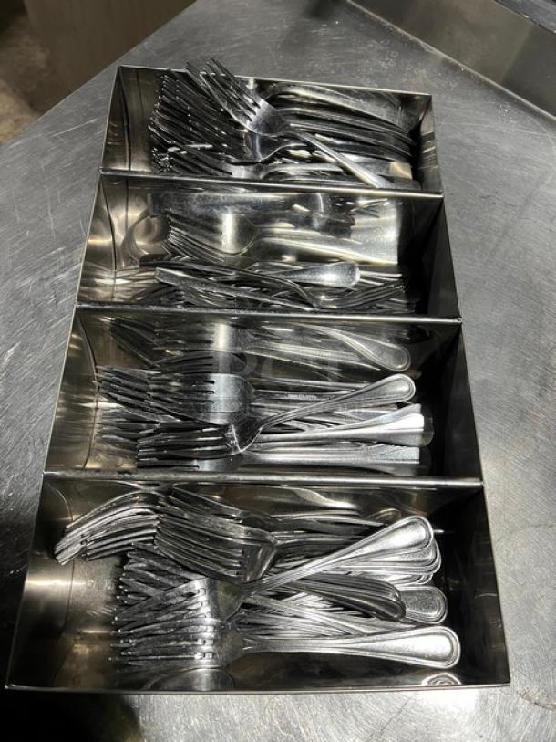 Lot of commercial forks in a 4-compartment stainless steel utensil organizer, used condition.