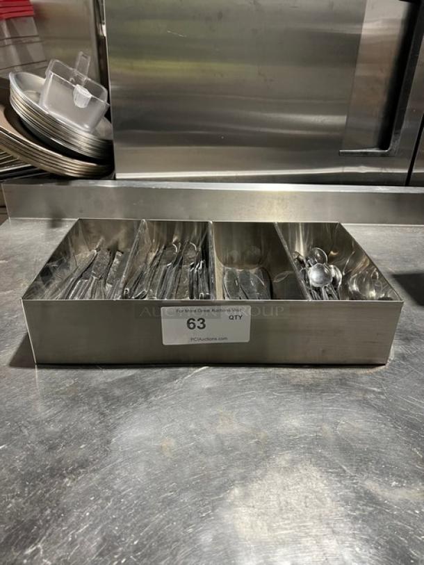 Lot of commercial miscellaneous knives and spoons in 4-compartment stainless steel organizer. Label reads "63 QTY, PCIauction.com".