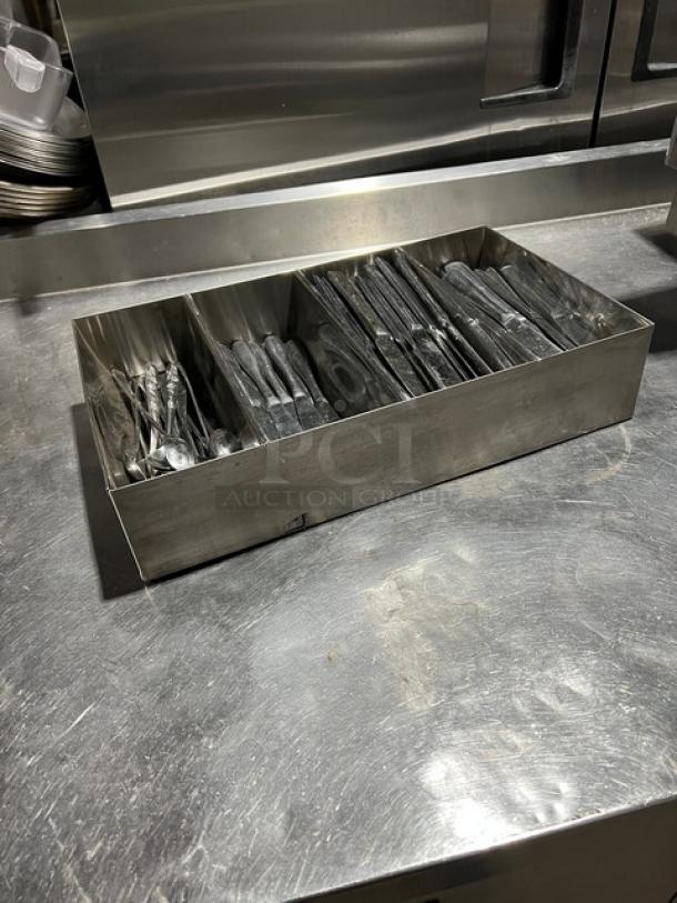 Lot of commercial knives and spoons in a four-compartment stainless steel utensil organizer, shown in good condition.