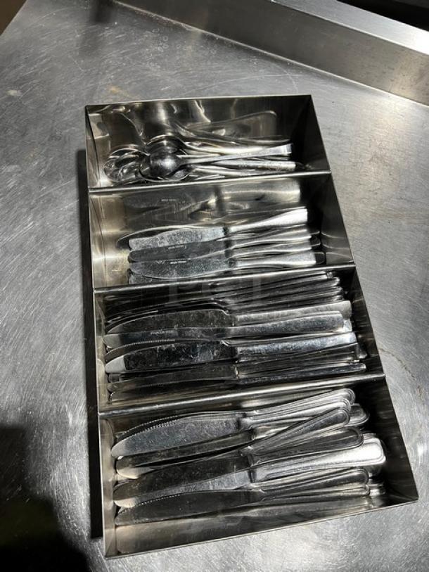 Lot of commercial knives and spoons in a four-compartment stainless steel utensil organizer, used condition.