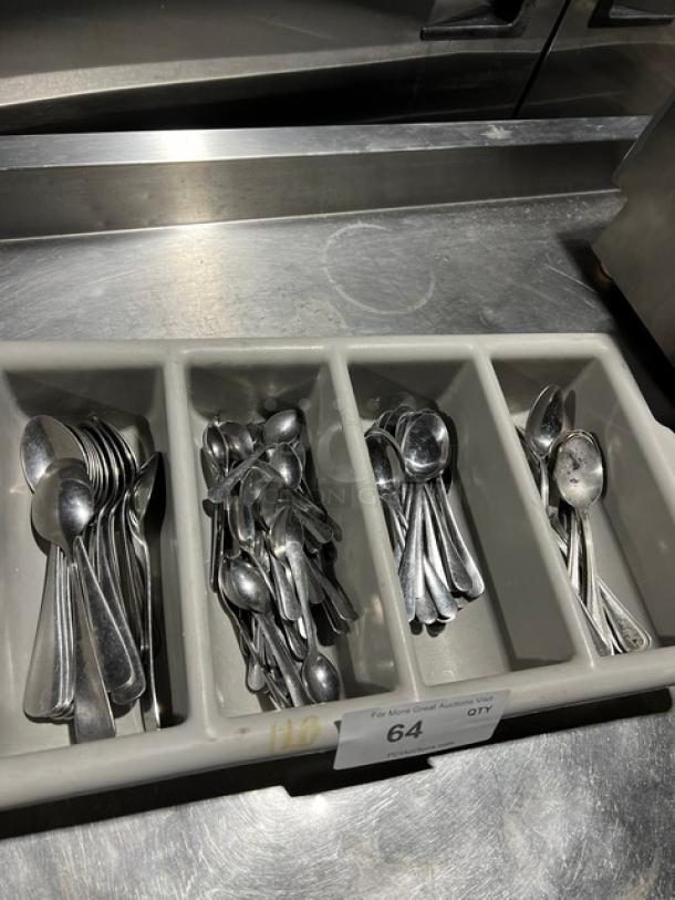 Lot of commercial spoons in a four-compartment utensil organizer. Spoons appear in functional condition.