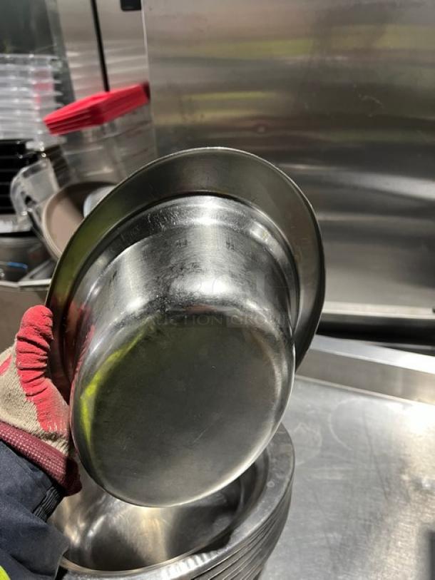 Commercial stainless steel oval food pan, shown in hand. Durable, polished finish, minimal wear. Ideal for catering use.