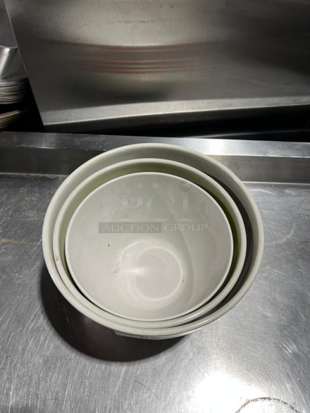 Set of three commercial round bowls, nested; white ceramic, smooth finish, in used condition, suitable for restaurant use.