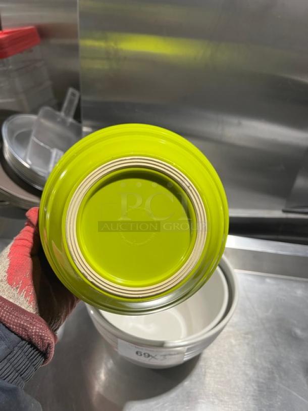 Commercial round assorted bowl, lime green base, used condition, stack of bowls in background, marked with "69X" label.