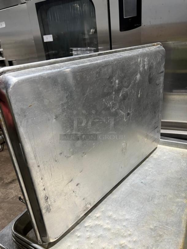 Commercial stainless steel full-size sheet pan, slightly worn, durable, ideal for baking.