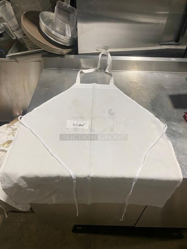 White full-length bib apron, commercial use, visible wear. Tag reads "82X60". Perfect for kitchen staff or chefs.