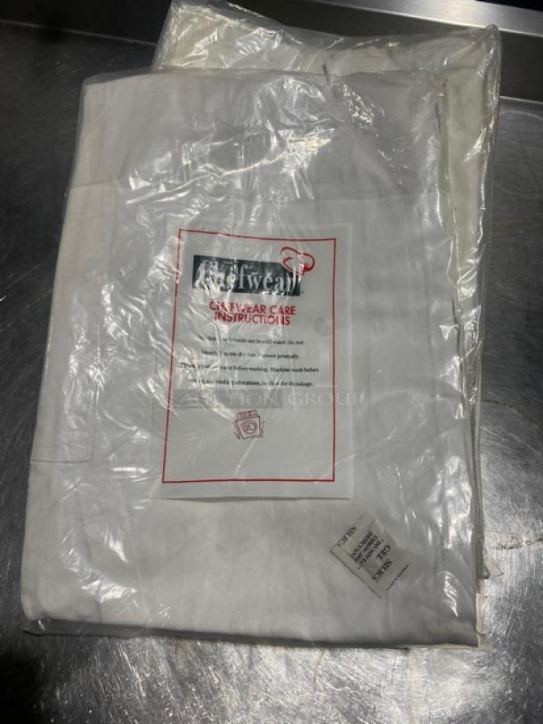 Chefwear white cotton bistro apron, new in package, model 1620-40. Features wide ties and pocket. Care instructions visible.