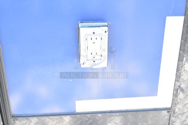 Southern Dimensions Shell Food Trailer exterior with visible power outlet. Blue panel, partial metal trim. Ready for equipment fitting.