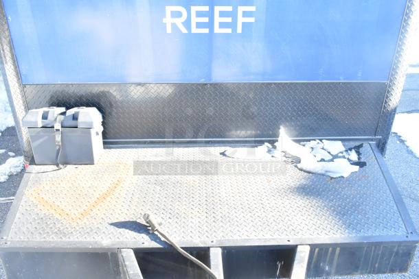 Southern Dimensions Shell Food Trailer platform with diamond plate flooring in sunlit condition. Visible electrical outlet and battery case.