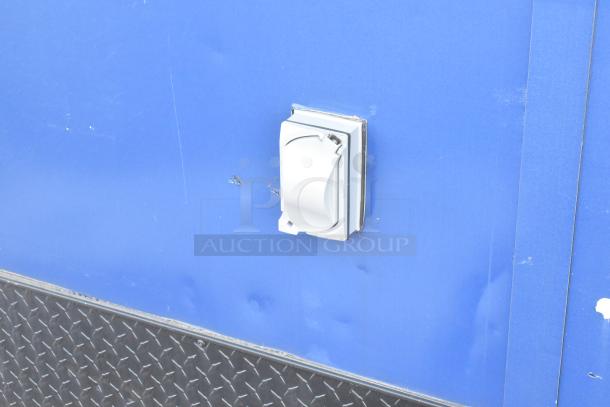 Southern Dimensions Shell Food Trailer exterior detail showing outlet, blue panel, and diamond plate trim. Ready for equipment.