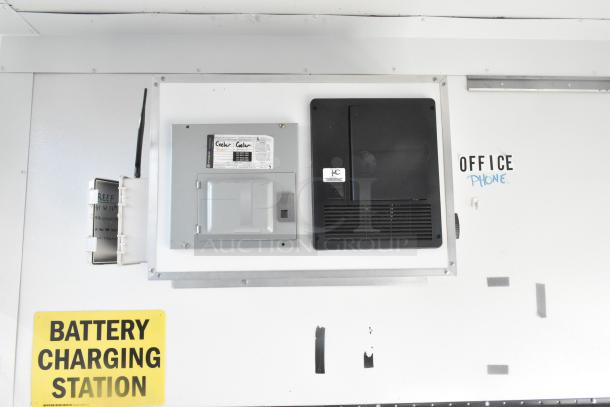 Battery charging station inside a Southern Dimensions shell food trailer. Features control panels and labeled compartments.
