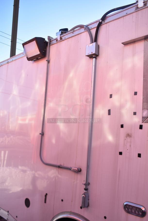 Exterior of a 2020 ATX 28' food trailer, showing wiring and lighting, in good condition. Fully equipped for commercial use.