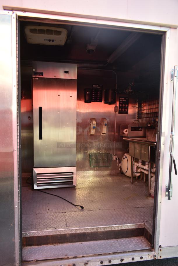 ATX 28' unbranded food trailer interior, equipped with Arctic Air fridge, sinks, and commercial appliances.