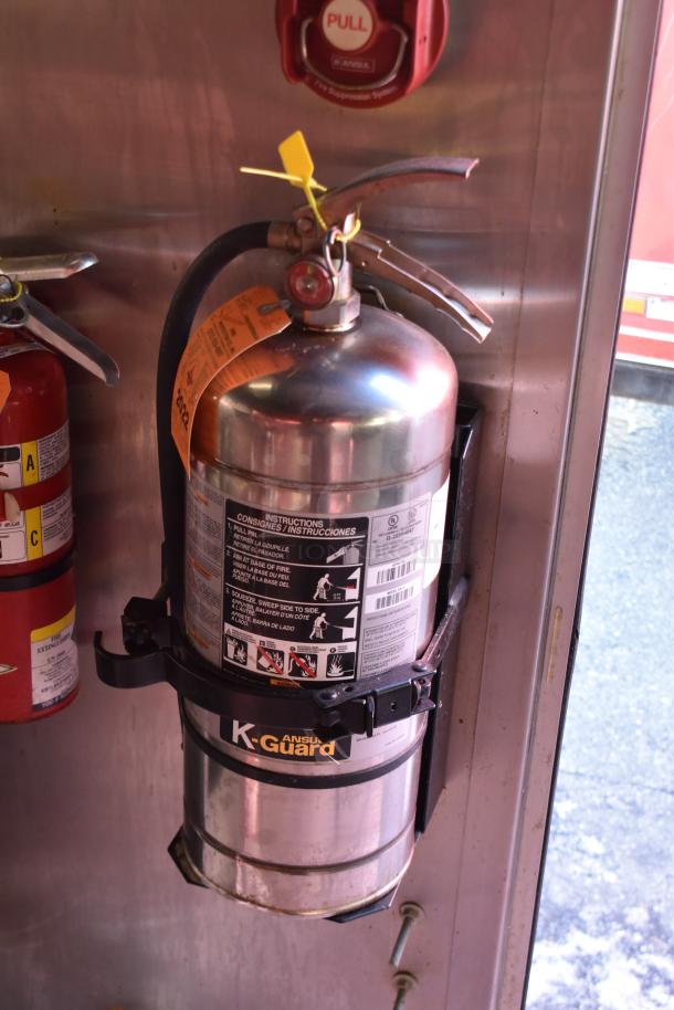 "ANSUL fire suppression system and K-Guard extinguisher inside ATX 28' food trailer. Safety equipment visible."