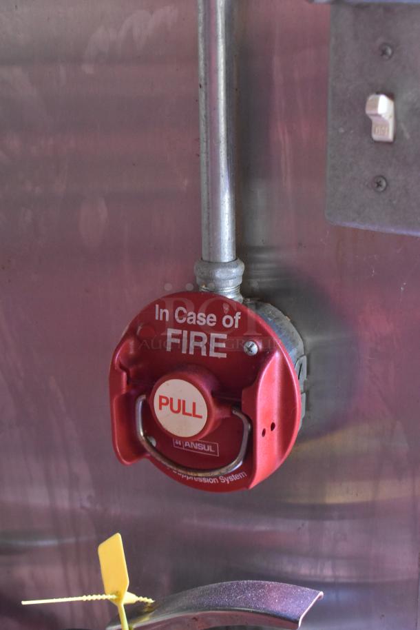 Fire suppression system pull station in ATX 28' trailer, labeled "In Case of Fire," essential safety feature.