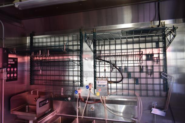 Interior of ATX 28' trailer with stainless steel sink, wire shelving, and ProGuard system. Commercial-grade setup ideal for food services.