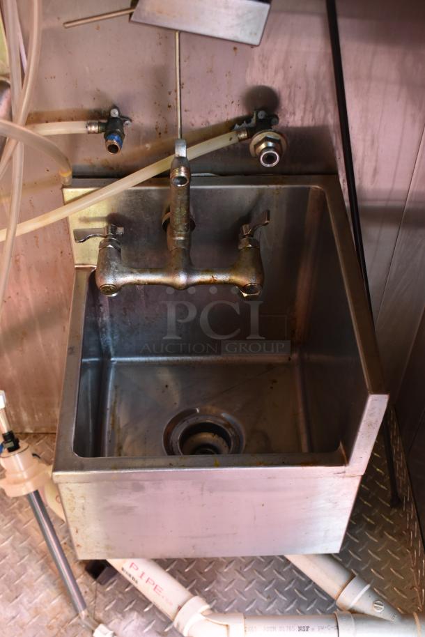 Stainless steel sink with dual faucets inside an ATX 28' food trailer, showing plumbing and metal floor plate.