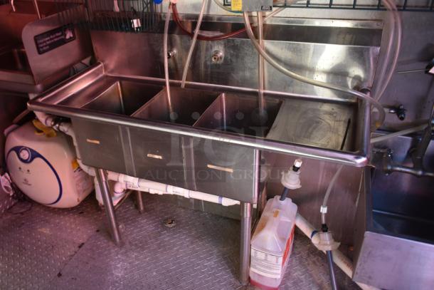 Interior of 28' ATX trailer with stainless steel triple sink setup and plumbing, suitable for food service use.