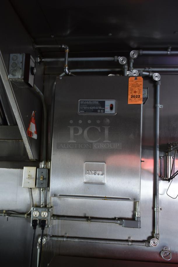 ATX 28' food trailer interior showing Ansul fire suppression system with 2022 inspection tag, electrical outlets, and piping.