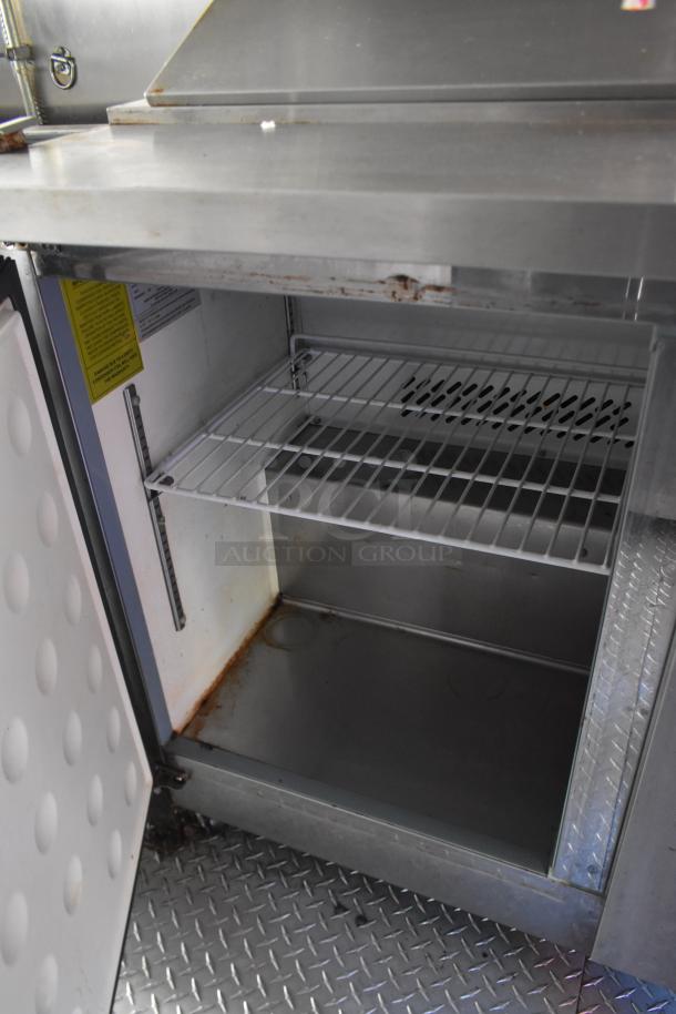 Interior of ATX 28' trailer showing Arctic Air cooler shelving, metal flooring, and equipment setup for cold storage.