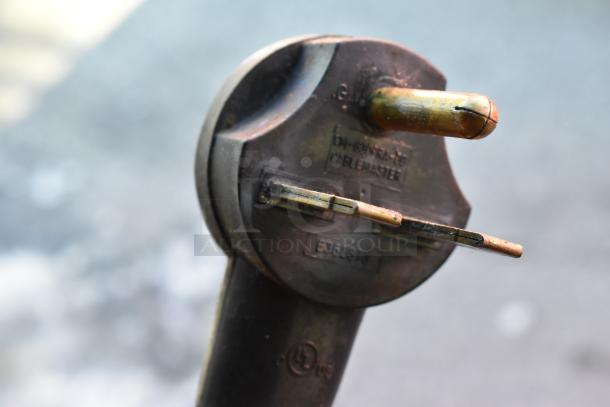 Close-up of an electrical plug labeled "CABLEMASTER," with visible model numbers, suitable for heavy-duty connections.