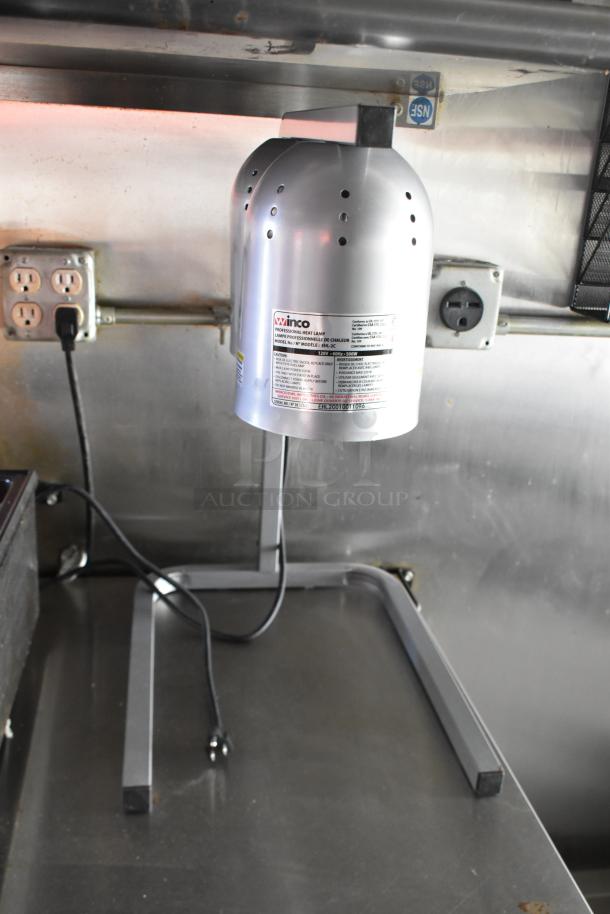 Winco professional heat lamp inside an ATX 28' unbranded cold food and beverage trailer with electrical outlets visible.