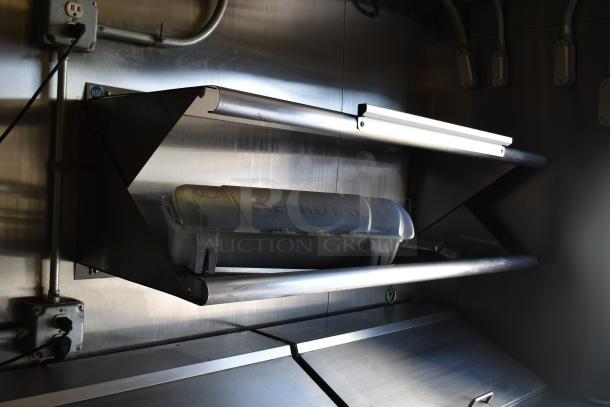Stainless steel interior of ATX food trailer with mounted Kenkut dispenser. Visible electrical outlets and piping.