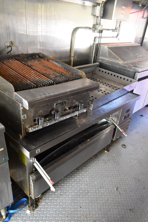 ATX 28' unbranded trailer interior with Asber charbroiler, prep tables, grease hood, and commercial equipment.