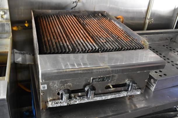 Commercial-grade Asber charbroiler in ATX 28' food trailer, steel exterior, visible wear, equipped for ghost kitchen use.