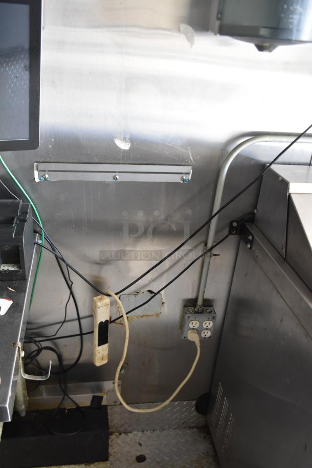 Interior detail of the ATX 28' food trailer showing electrical outlets, cords, stainless steel wall, and durable flooring.