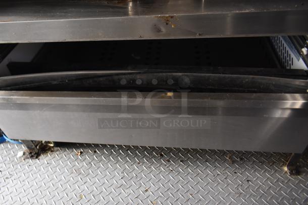 Interior view of ATX 28' food trailer showing stainless steel equipment and diamond plate flooring, indicating commercial use.