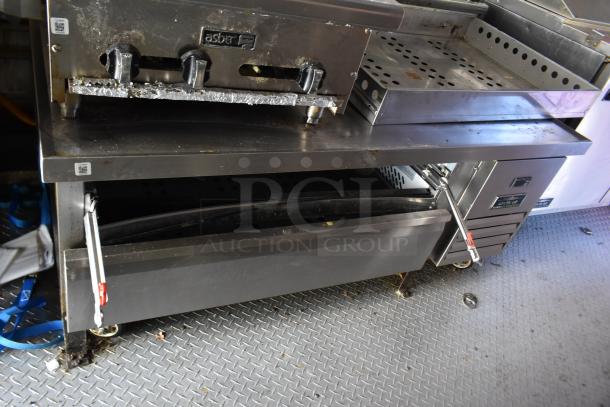 ATX 28' trailer interior with Asber charbroiler, Arctic Air coolers, and stainless steel surfaces. Ideal for various food concepts.