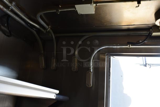 Interior view of the ATX 28' trailer, showcasing overhead metal piping connected to the grease hood system.