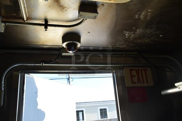Interior view of ATX 28' food trailer showing ceiling with surveillance camera, exit sign, and wiring.