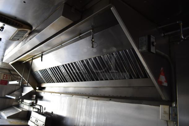 Interior view of ATX 28' food trailer showing stainless steel grease hood with ventilation and electrical fixtures.