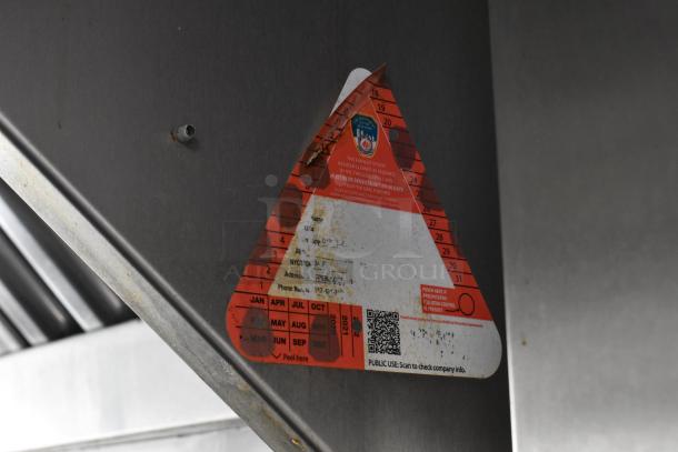Triangular inspection sticker on metal surface showing maintenance details, including date punched, and a QR code for company info.