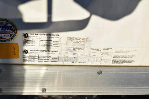 Tire and loading information label on ATX 28' trailer. Lists tire sizes, cold tire pressure, and load limits. Forest River, Inc. info visible.