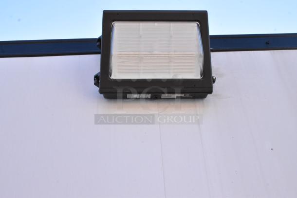 Exterior wall-mounted light fixture on a cold food and beverage retail trailer.